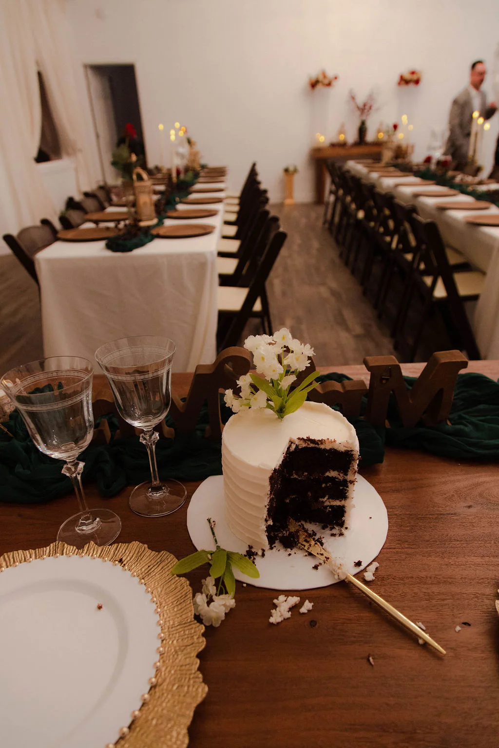 Wedding cake in front of reception tables at Velora